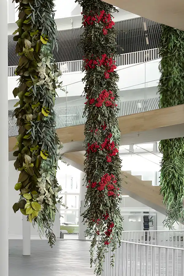 Innenraum mit modernen Treppenanlagen und hängenden Moos- und Pflanzenelementen in Grün und Rot von MoosMoos, exklusive Naturinstallation an der Decke