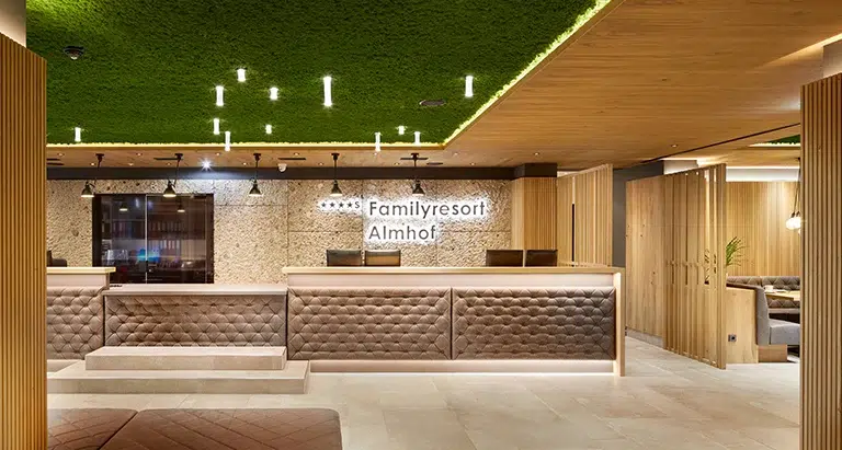 Exklusive Hotelrezeption mit modernem Interieur, Holzdetails und einer grünen Decke aus Moos von MoosMoos für nachhaltiges Design
