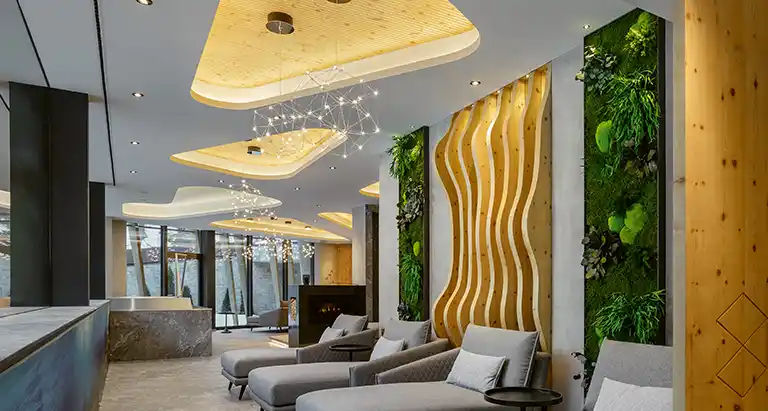 Moderne Hotel-Lounge mit geschwungenen Holz-Elementen, Wand aus Moos und stilvoller MoosMoos-Decke als nachhaltiges Design-Highlight.