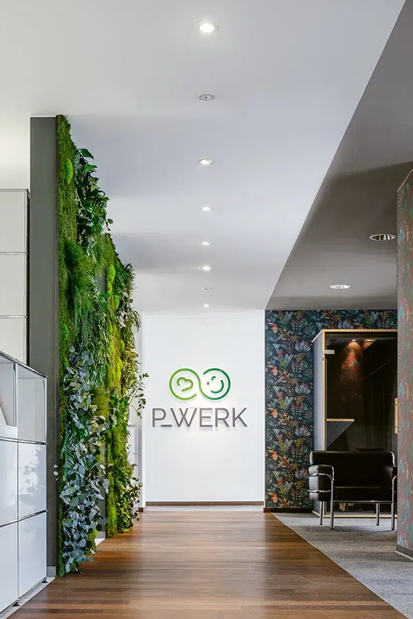 Grüne MoosMoos wand aus Moos im Büro von P.Werk mit Logo, für frisches Raumklima und modernes Design
