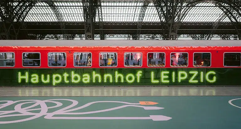 Große Wand aus Moos mit Leuchtschrift „Hauptbahnhof Leipzig“, urbane Installation von Moosmoos.