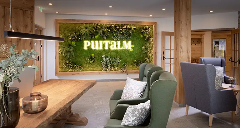 Empfangsbereich des Hotels Puitalm mit einer stilvollen MoosMoos Wand aus Moos – natürliche Dekoration und nachhaltige Raumakustik.