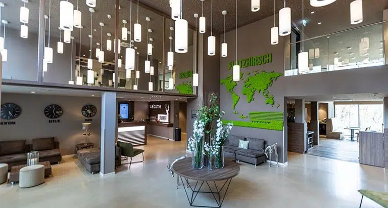 Moderne Hotellobby mit großflächiger Wand aus Moos und integrierter Weltkarte von MoosMoos – nachhaltiges Design und natürliche Akustiklösung.