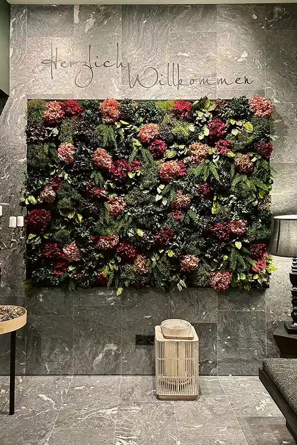 Exklusive MoosMoos Wand aus Moos mit roten und grünen Blüten im Hotelflur als dekoratives Bild aus Moos.