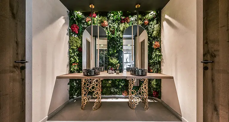 Stilvolles Badezimmer mit Doppelwaschtisch, Spiegeln und dekorativer Wand aus Moos mit Pflanzen und Blumen  von MoosMoos, nachhaltiges Naturdesign für moderne Bäder