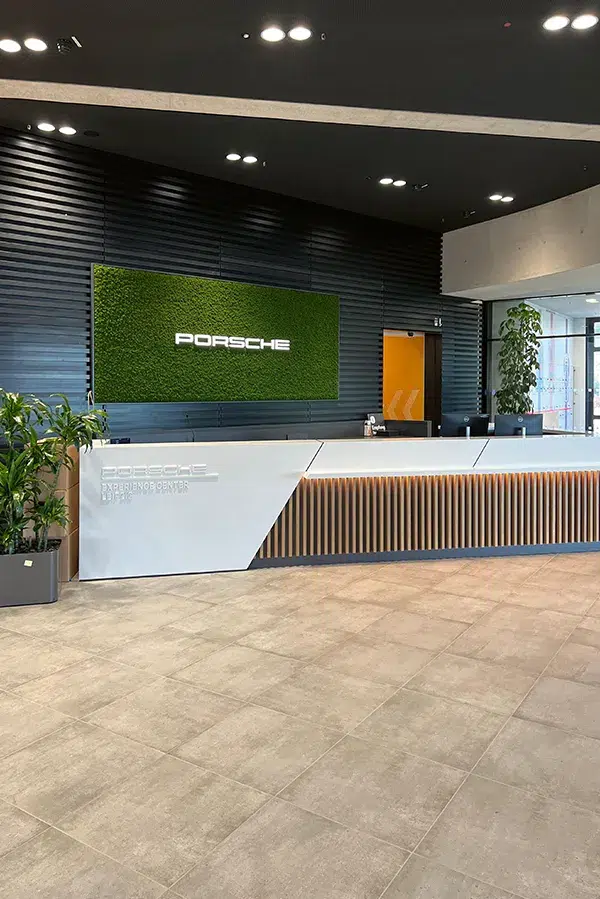 oderne Empfangsbereich-Gestaltung bei Porsche mit einer MoosMoos Wand aus Moos für nachhaltiges Design und natürliche Raumwirkung.