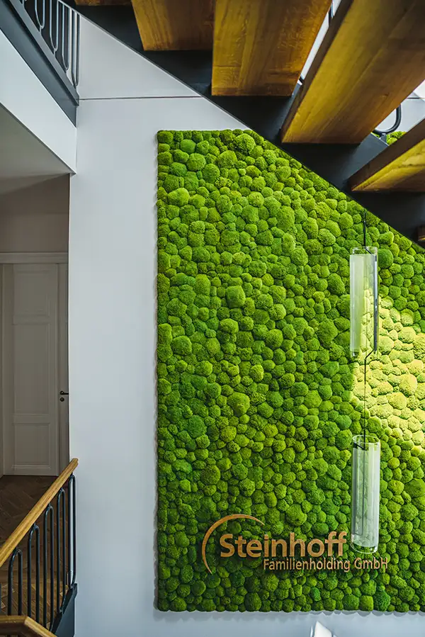 Grüne Wand aus Moos von MoosMoos im Treppenhaus der Steinhoff Familienholding GmbH – nachhaltiges Interior-Design.