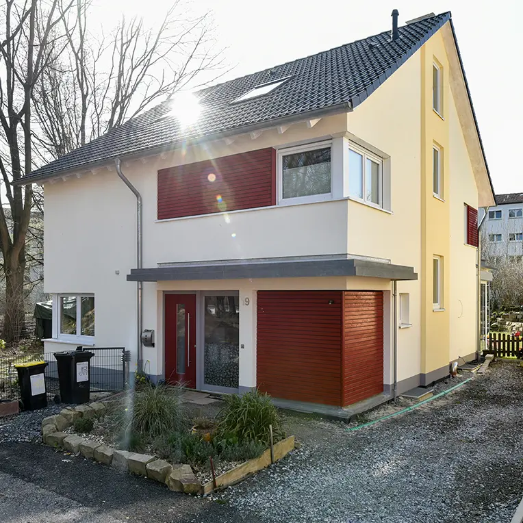 Zweifarbige Fassadengestaltung Einfamilienhaus mit gelb-weißer Putzfassade und roten Akzenten, Uwe Walter Premium-Verbund MOOSMOOS Mallorca