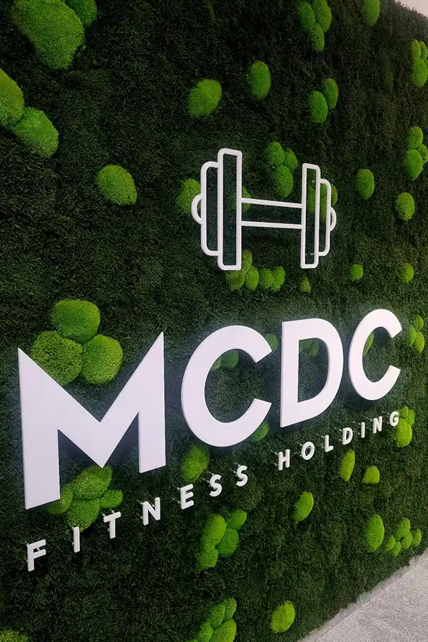 Mooswand mit integriertem MCDC Fitness Holding Logo im Fitnessstudio